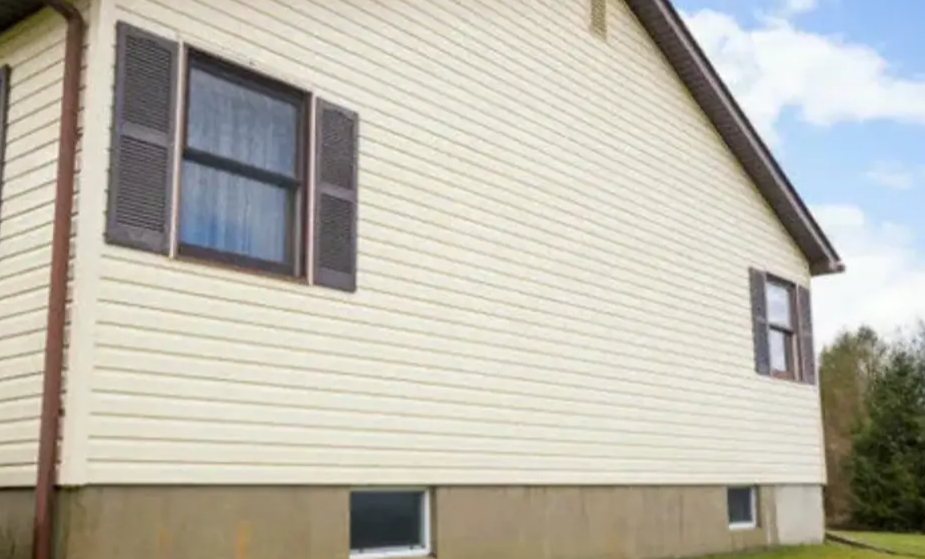 Residential home with newly installed beige vinyl siding, showcasing professional siding services and exterior home improvement.
