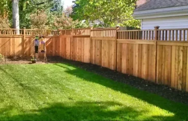Newly constructed metal fence along a residential property line, showcasing expert fencing services.