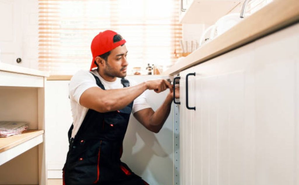Professional handyman installing a kitchen cabinet handle