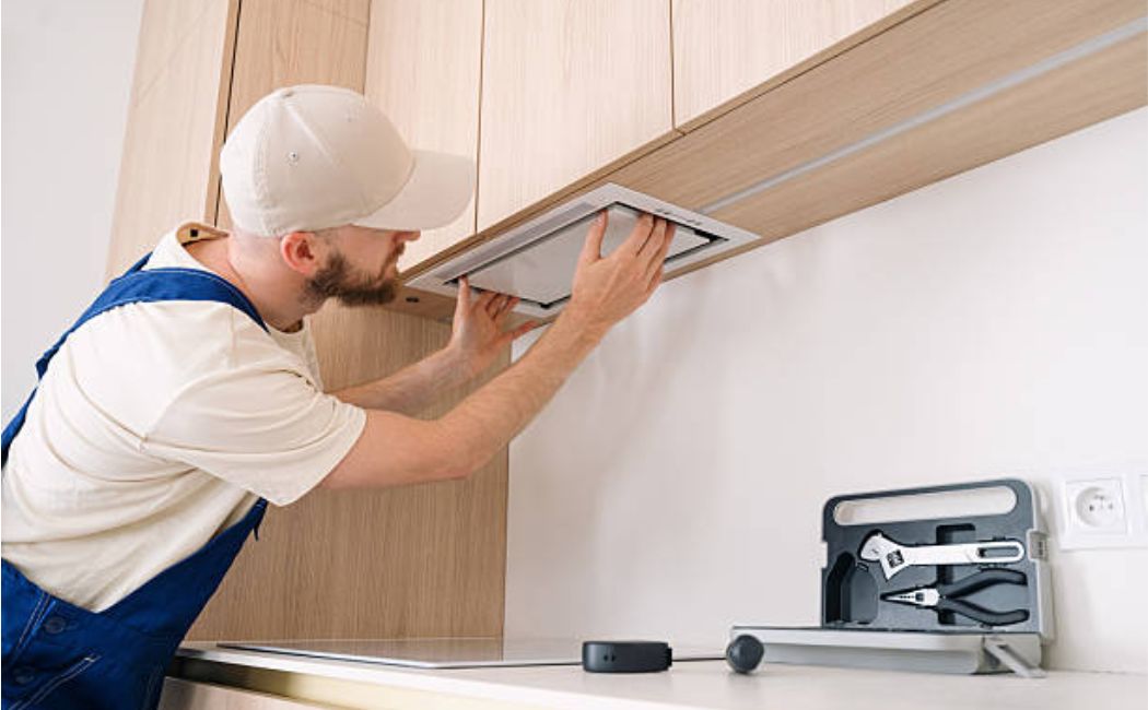 A man is fixing new cabinets in a kitchen renovation