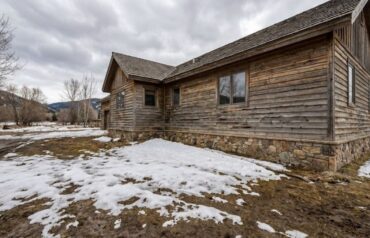 Montana home exterior after winter, showing wood siding damage from snow and ice