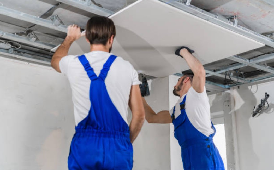 Construction professionals installing plaster ceiling sheets