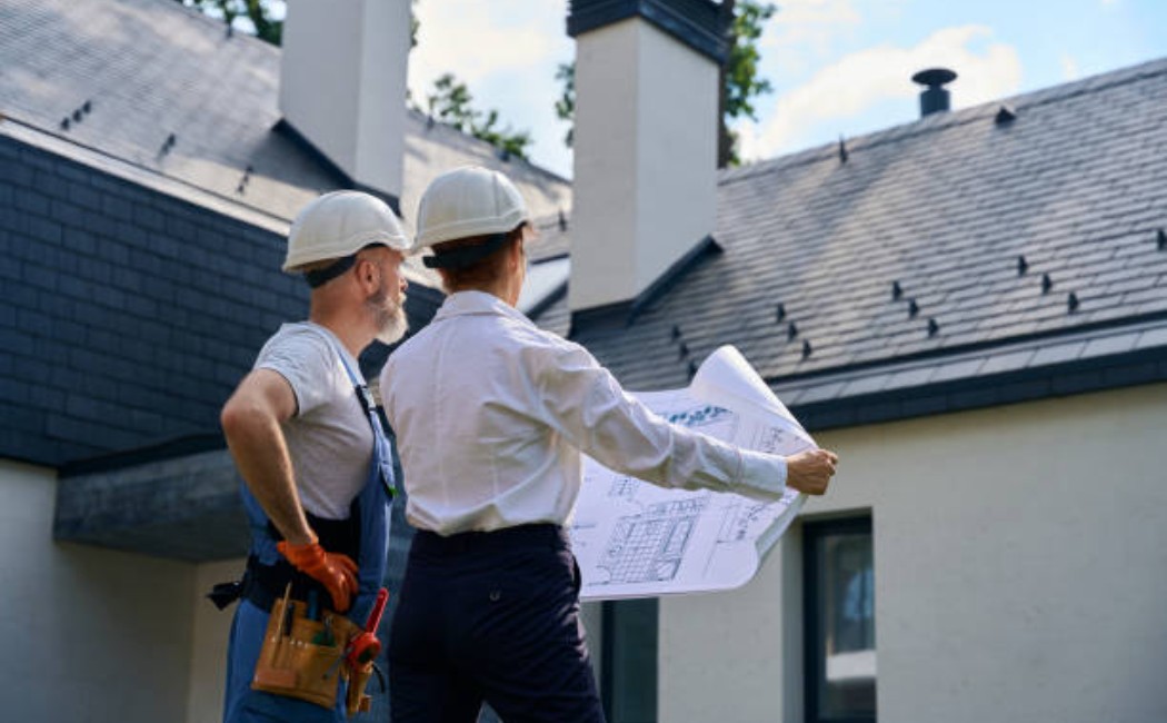Home construction experts inspecting completed exterior renovation work