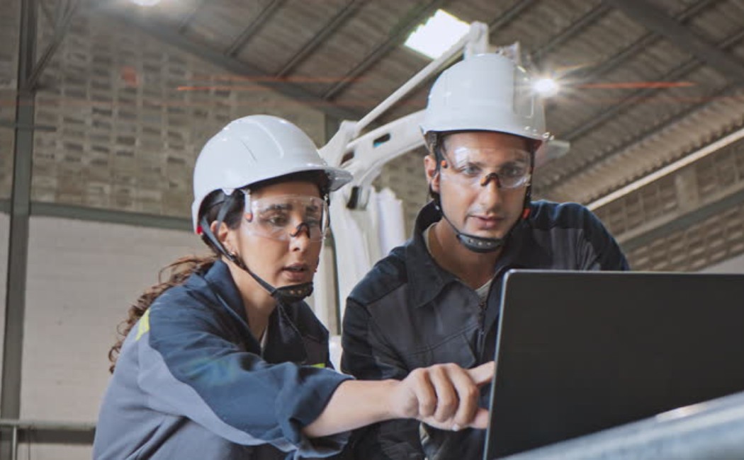 Professional engineers reviewing construction project plans on a laptop