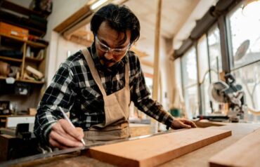 A carpenter measuring wooden materials for furniture work