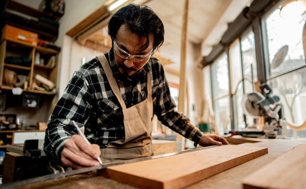 A carpenter measuring wooden materials for furniture work