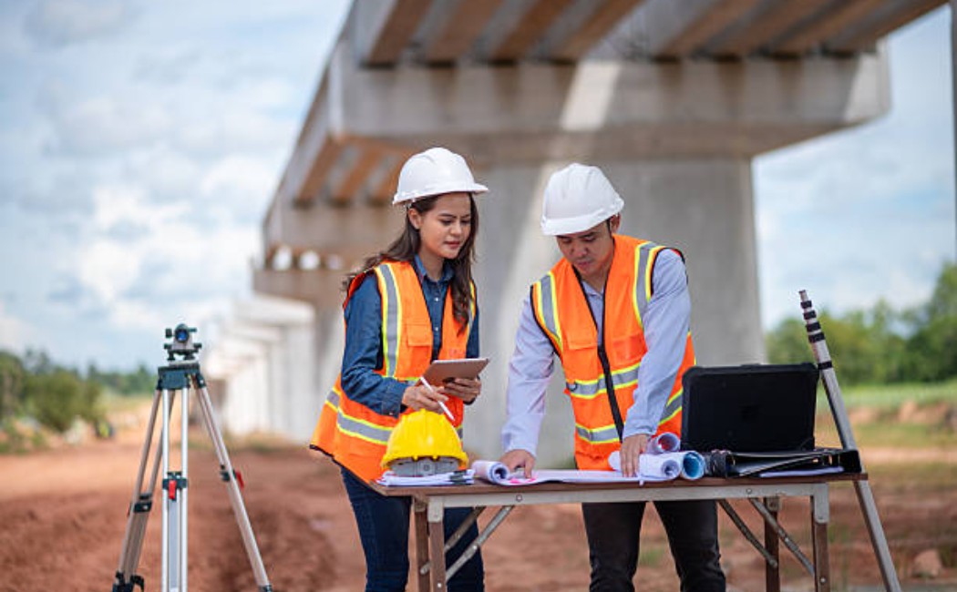 Engineers reviewing construction blueprints at an active building site.